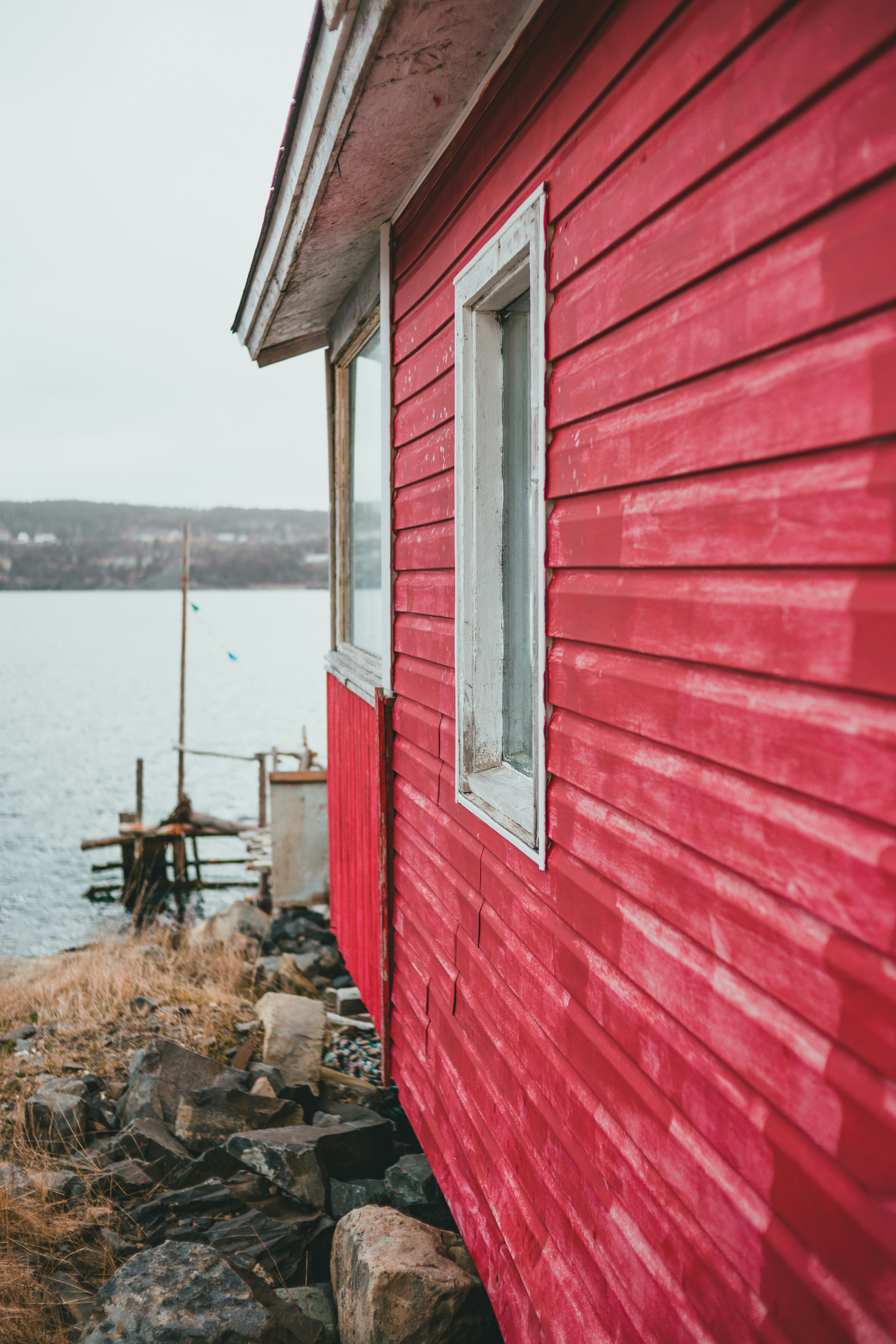 brown wooden house near body of water during daytime